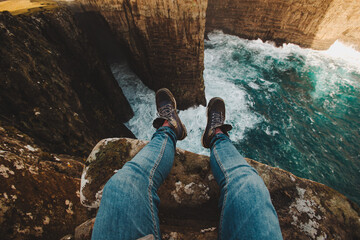 person sitting on a side of a high cliff - 635212913