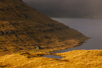 Lonely lake house on the side of a mountain in Faroe islands - 635212929
