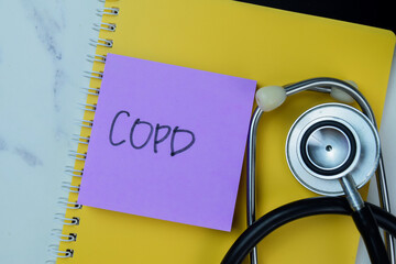 Concept of COPD write on sticky notes with stethoscope isolated on Wooden Table.