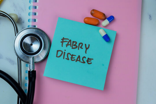 Concept of Fabry Disease write on sticky notes with stethoscope isolated on Wooden Table.