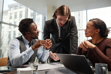 Group of successful business people discussing work over table in luxury office