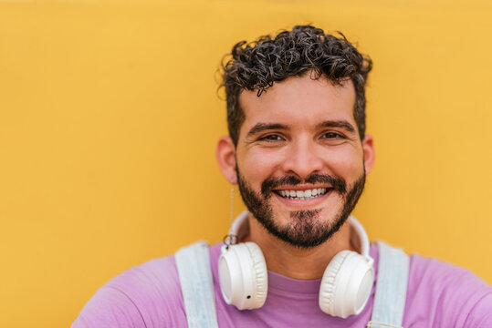 Young Bearded Man Looking At Camera Against Yellow Background