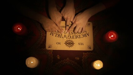 People hands moving together over the spirit board game, reading the message from ghosts.