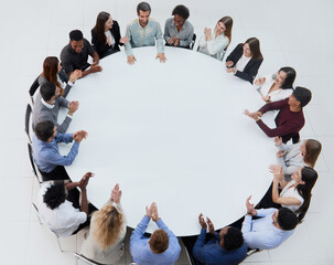 Businessmen or office workers are sitting at a round table in casual clothes.