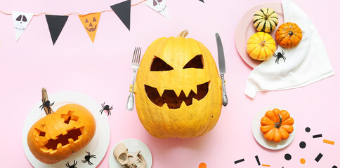 Stylish Halloween table setting with carved pumpkins on light pink background