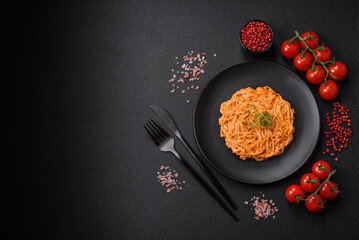 Delicious fresh pasta consisting of thin noodles, red pesto rosso sauce with spices and herbs