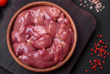 Fresh raw chicken or turkey liver in a ceramic plate with salt, spices and herbs
