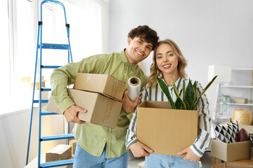 Young couple with cardboard boxes in bedroom on moving day