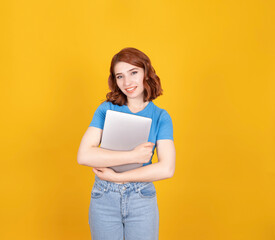 Holding closed laptop, portrait of young redhead European woman holding closed laptop. Positive, confident, smiling girl looking camera. Studying, learning, university student, career concept image.