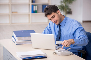 Fototapeta premium Young male employee working in the office