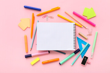 Composition with blank notebook and different school supplies on pink background