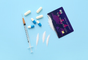 Composition with drugs, syringe and credit card on color background