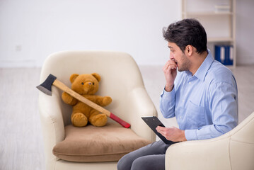 Young male psychologist meeting with toy bear