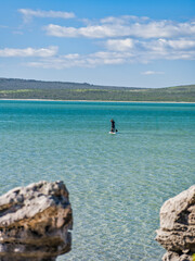 Father and daughter Standup paddle boarding in the West Coast National Park turquoise blue lagoon, Western Cape, South Africa