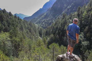 A man on the mountain viewpoint looking at the valley.