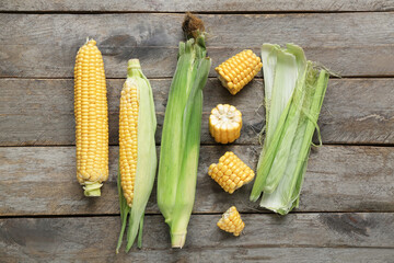Fresh corn cobs on grey wooden table