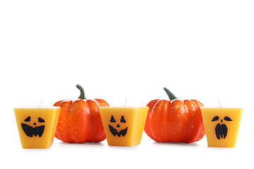 Wax candles and pumpkins for Halloween on white background