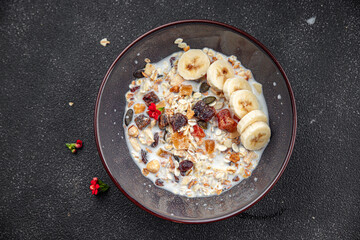 granola bowl with milk dried fruit and fresh banana tasty breakfast ready to eat healthy meal food snack on the table copy space food background rustic top view keto or paleo diet