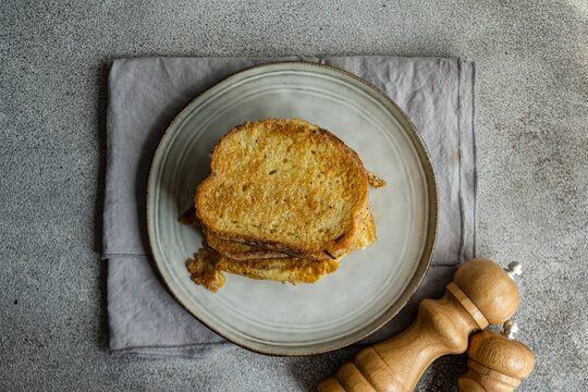 Slices of fried bread with egg coating on ceramic plate