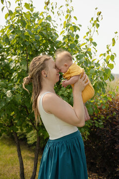 Loving woman carrying baby while standing in park