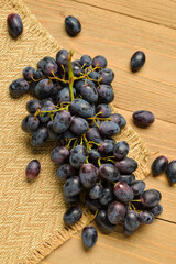 Sweet black grapes on wooden background