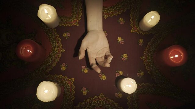 Top view, woman chiromancer holding a female clients hand and reading her lines on open palm. HDR BT2020 HLG Material.