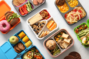 Lunchboxes with different delicious food on gradient background