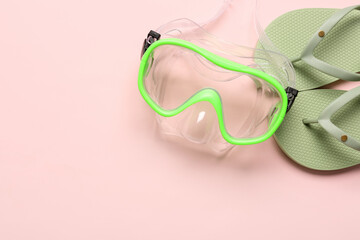 Snorkeling mask and flip-flops on color background