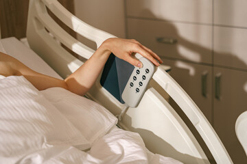 Close up of woman patient hand presses the buttons on the hospital bed. High quality photo
