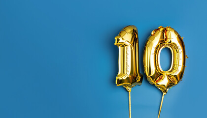 Banner with number 10 golden balloon with copy space. Ten years anniversary celebration concept on...