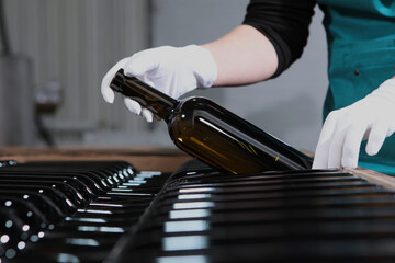 New wine is bottled and stacked for storage.Bottled wine at winery.Bottle of wine in his hands.