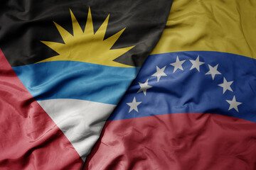 big waving realistic national colorful flag of antigua and barbuda and national flag of venezuela .