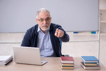 Old male teacher in the classroom