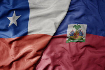 big waving realistic national colorful flag of chile and national flag of haiti .