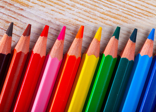 Image of multicolored wooden pencils on wooden surface
