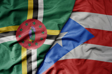 big waving realistic national colorful flag of dominica and national flag of puerto rico .