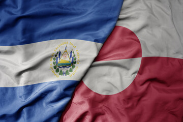 big waving realistic national colorful flag of el salvador and national flag of greenland .