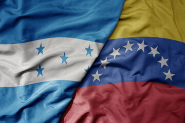 big waving realistic national colorful flag of honduras and national flag of venezuela .