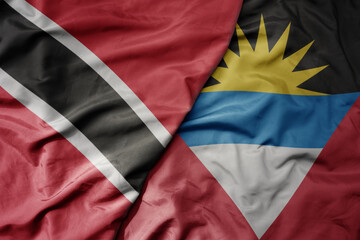 big waving realistic national colorful flag of trinidad and tobago and national flag of antigua and...