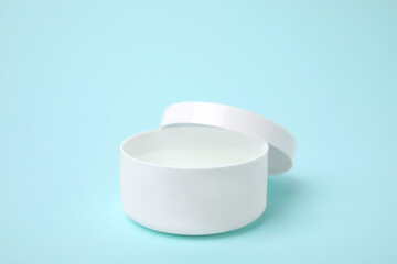 Jar of petroleum jelly on light blue background