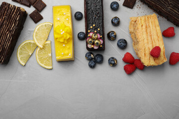 Flat lay composition with different tasty cakes on light grey table. Space for text