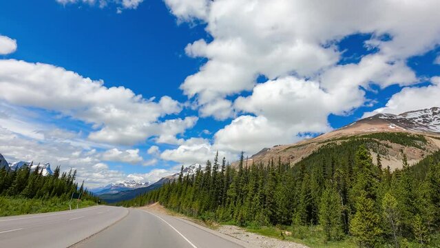 Road trip for camping in Jasper national park before the and of summer mid september. traveling by car with beautiful scenery, beautiful enormus mountains and green pine trees under dark blue sky