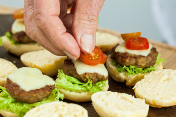 Step by step preparation of mini burgers. Homemade mini burgers for children or appetizers. Small hamburgers. Assembling burgers