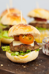 Ready to serve mini hamburgers. Step by step preparation of mini burgers. Homemade mini burgers for children or appetizers. Small hamburgers.