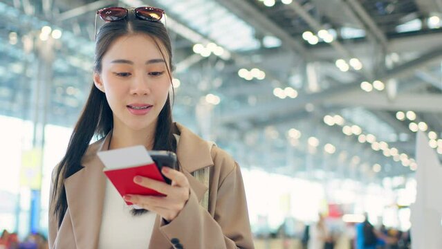Asian young woman passenger checking depature boarding pass in airport. 