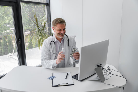 Doctor conducts online consultation with patient and showing pills to him. High quality photo