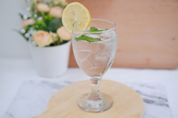 Glass of water with lemon and mint on a wooden table, stock photo