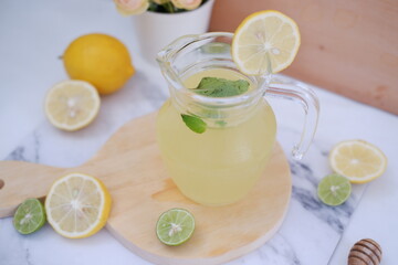 Lemonade with fresh lemon and mint leaves on a white background
