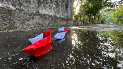 Paper boat Red and white floating on the water.