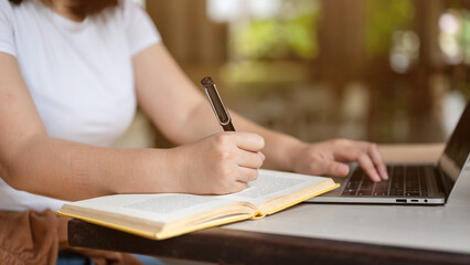 Cropped image of a female freelancer or college student working on her project on her laptop